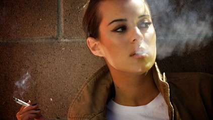 Eine junge Frau raucht eine Zigarette