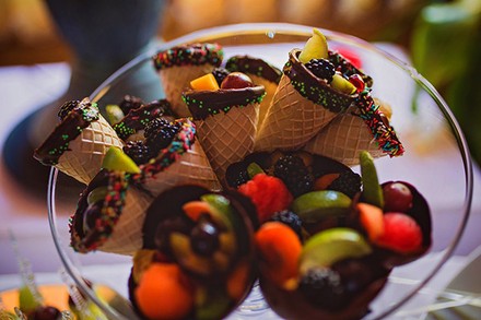 Mehrere Eiswaffeln mit Schokolade und Früchten in einer Schüssel