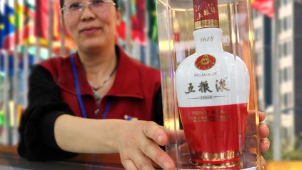 Eine Asiatin präsentiert eine hochwertige Flasche chinesischen Schnaps