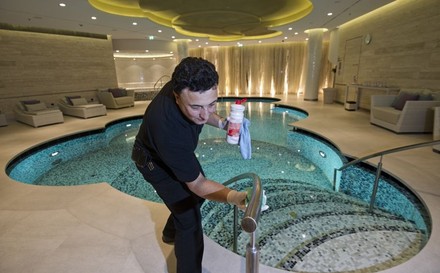 Mann beim Reinigen eines Hotelpools