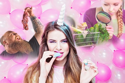 Ein Mann beißt in ein Stück Fleisch, eine Frau mit Einhornattrappe auf dem Kopf isst ein Fruchtgummi und eine andere Frau untersucht Gemüse mit einer Lupe. Im Hintergrund sind Luftballons zu erkennen