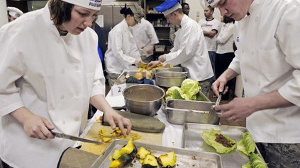 Mehrere Köche und Küchenhilfe bei der Arbeit