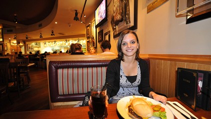 EIne junge Dame mit Burger in einem Hard Rock Cafe