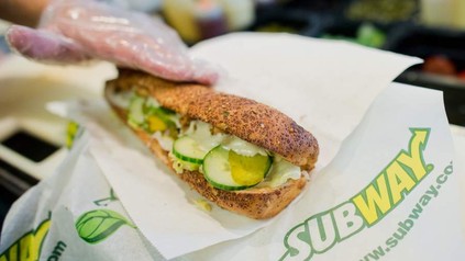 Ein frisches Subwaysandwich wird von einem Mitarbeiter eingepackt
