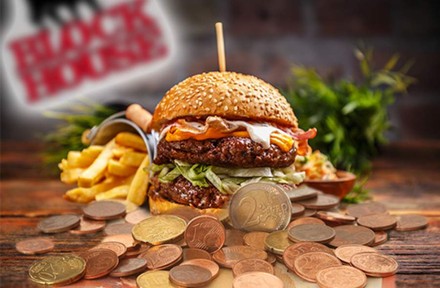 Ein Burger und Pommes vor dem Block House Logo, davor mehrere Cent- und Euromünzen