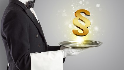 Ein Kellner serviert ein Paragrafenzeichen