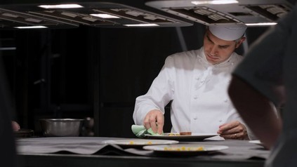 Koch putzt Teller mit Lappen