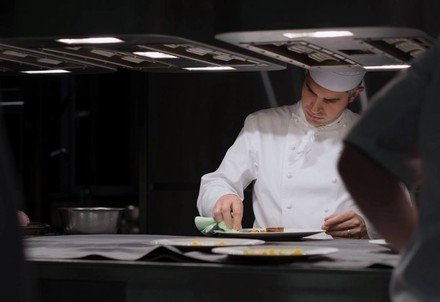 Koch putzt Teller mit Lappen