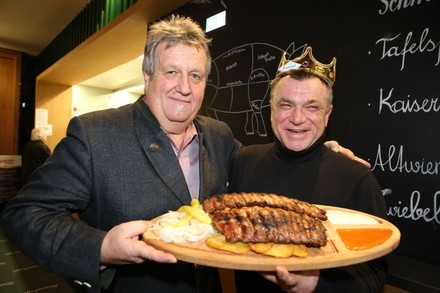 Erich Homolka und Oswald Rössler halten zusammen ein Brett mit Rippchen