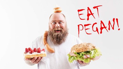 Ein bärtiger Mann hät eine belegte Semmel und eine Waffel mit Sahne und Erdbeeren in den Händen. Um seine Schulter liegt eine Wurstkette und auf seinem Kopf liegt ein Krapfen. An der Seite steht EAT PEGAN