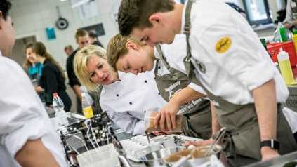 Mehrere junge Köche arbeiten in einer Großküche