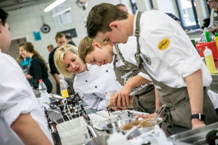 Mehrere junge Köche arbeiten in einer Großküche