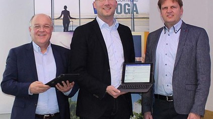Drei Personen halten iPads hoch