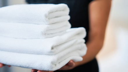 Housekeeper mit frischen Handtüchern