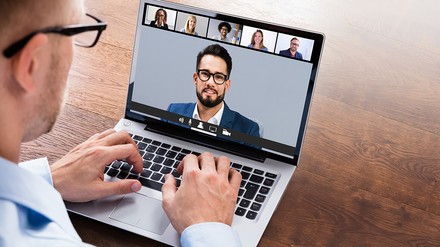 Businessmann mit Brille führt eine Online-Konferenz am Laptop
