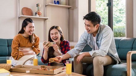 Eine Gruppe junger Leute beim Pizzaessen.