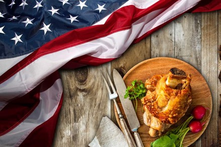 Eine us-amerikanische Fahne liegt neben einem Teller mit Schweinshaxe