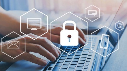 Hände geben etwas am Laptop ein