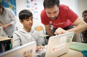 Mann zeigt Kind etwas auf Laptop