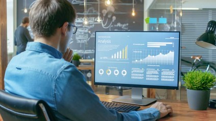 Ein Mann sitzt vor seinem Computer und begutachtet eine Analyse