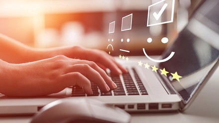 Laptop mit Bewertung Emojis im Vordergrund