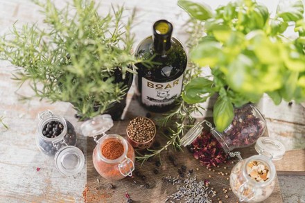 Eine Flasche Boar Gin steht inmitten der Zutaten für die Zubereitung