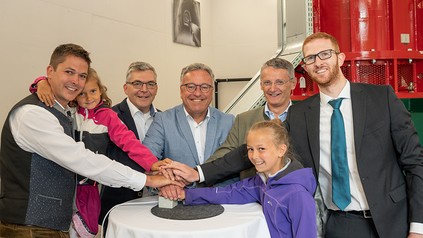 Eine Gruppe Menschen vor einem Wasserkraftwerk