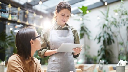 Eine Kellnerin mit einer Gästeliste