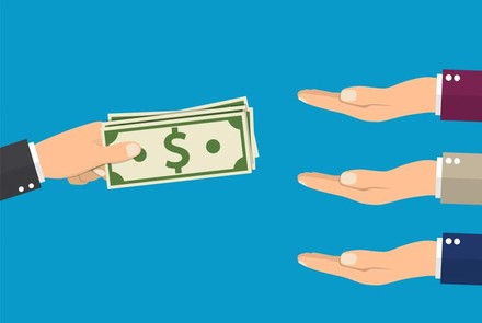 Eine Hand hält ein paar Geldscheine, während drei Hände die Handflächen ausstrecken um das Geld zu erhalten