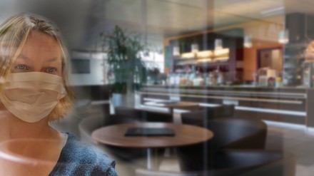 Eine Frau mit Mundschutz im Restaurant