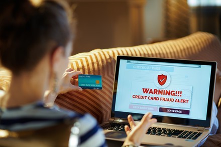 Eine Frau mit Kreditkarte vor einem Laptop