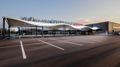 Der neue Kastner Markt von außen mit gewellter Überdachung auf dem Parkplatz