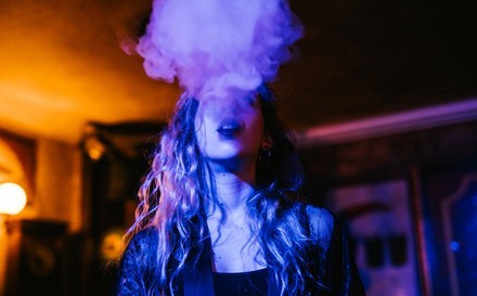 Frau bläst Rauch aus