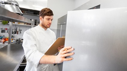 Ein Kontrolleur öffnet ein Küchenkühlhaus