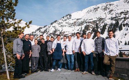 Die Spitzenköche bei einem Gruppenfoto vor verschneiten Bergen