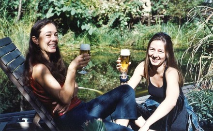 Zwei Frauen an einem Gewässer trinken Bier