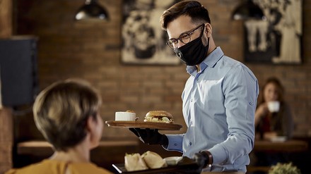 Gastronom mit Mundschutz