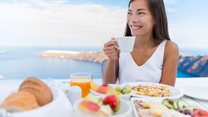 Eine Frau frühstückt auf einem Kreuzfahrtschiff