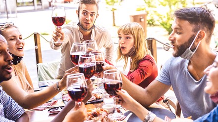 Freunde im Restaurant stoßen mit Wein an