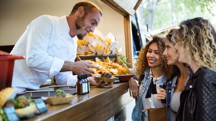 3 junge Frauen lassen sich an einem STreetfood-Stand bedienen