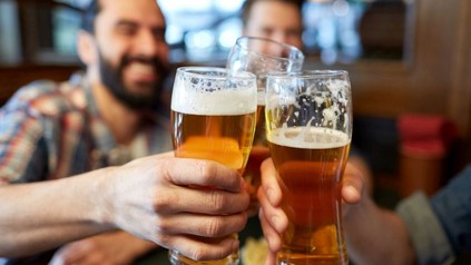 Drei Männer stoßen mit Biergläsern an