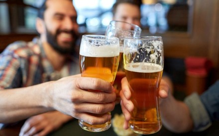 Drei Männer stoßen mit Biergläsern an