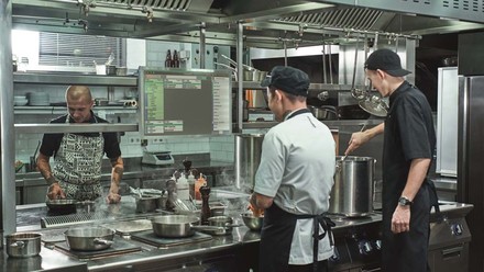 Koch steht vor dem gastronovi Küchenmonitor