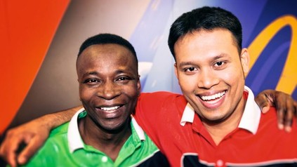 Asiat und Afrikaner lachen in die Kamera