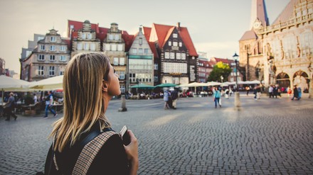 Frau blickt auf einem Marktplatz nach oben