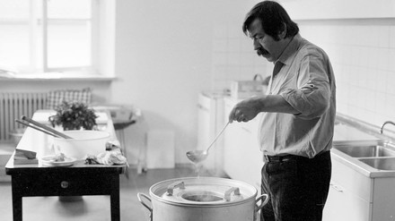 Günter Grass steht neben einem großen Topf mit Suppenkelle in einer Küche.