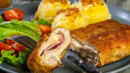 Ein angeschnittenes Cordon bleu auf einem Teller.