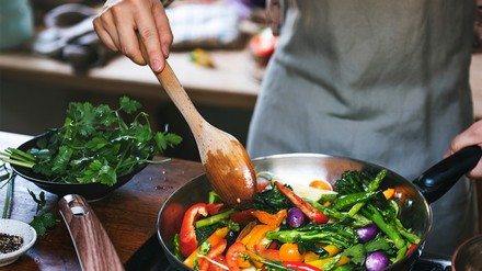 Eine Frau kocht ein veganes Gericht,