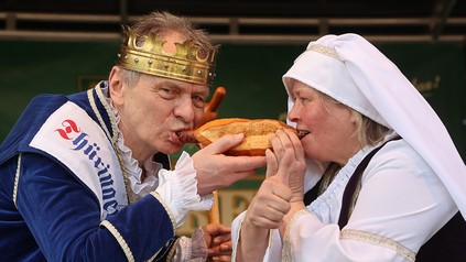 Es geht um die Wurst: Norbert Abt (l), Thüringer Bratwurstkönig, und Susanne Sever in Vertretung der Thüringer Wurstkönigin beißen in eine Rostbratwurst beim Festival "Rostkultur 2023".
