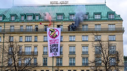 Klimaaktivisten zünden Rauchbomben von einem Balkon des Hotels Adlon.